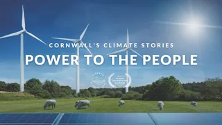 Wind turbines in a field with solar panels. Text that reads 'Cornwall's climate stories power to the people'