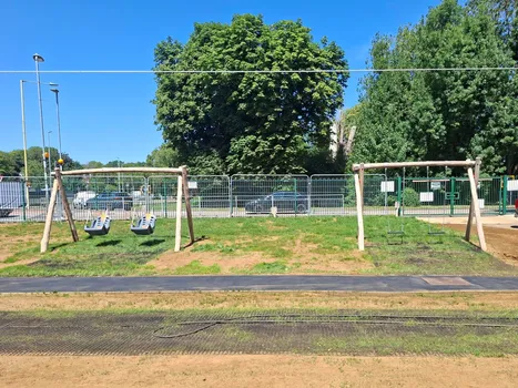 Outdoor play area with wooden framed swings