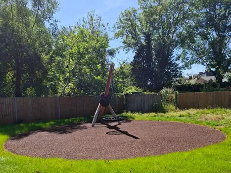 Outdoor play area with wooden framed tyre swing
