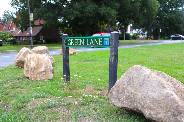 The boulders surrounding 'Green Lane' road sign