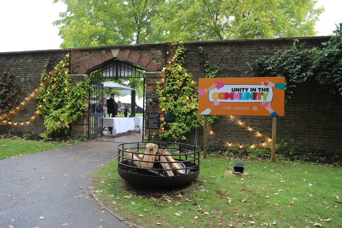 Doorway within an old wall with an orange sign that reads 'Unity in the Community'