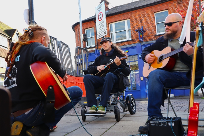 Good Vibration volunteers jamming. Two are holding a guitar and another is holding a ukulele.