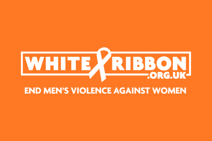 Orange background with the White Ribbon logo. Text that reads 'White Ribbon.org.uk end men's violence against women'.