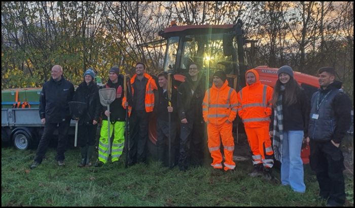 Council officers posing with EA officers at the River Colne in front of a red tractor