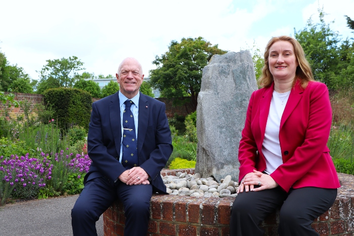 Cllr Stephen Giles-Medhurst and Cllr Louise Price sitting by the fountain in the Rose Garden, surrounded by flowers