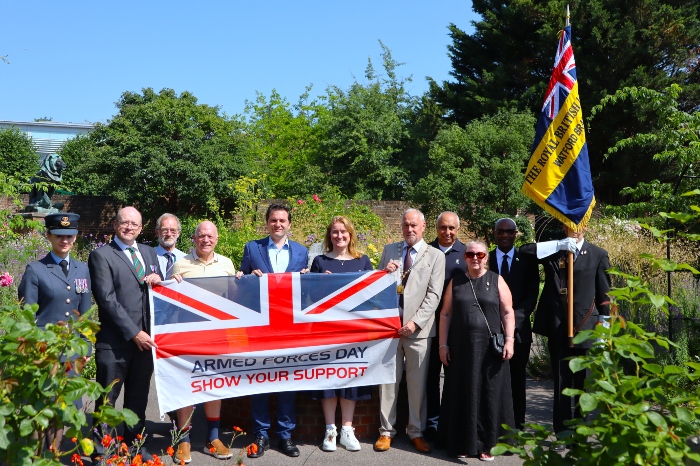 Councillors and partners in the Rose Garden holding the Armed Forces Day Flag