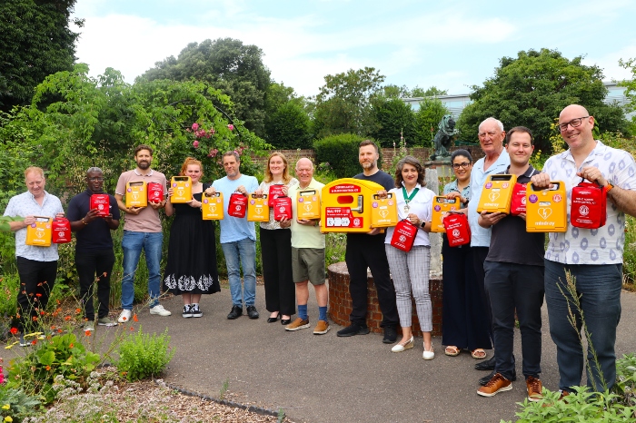 Three Rivers District Council staff and councillors and volunteers holding 10 yellow defibs and red bleed kits