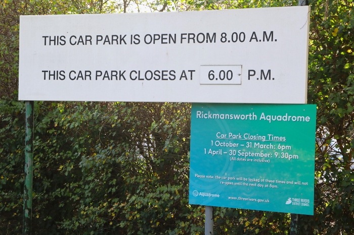 A white sign that outlines the car park opening times at the Aquadrome (from 8am to 6pm)
