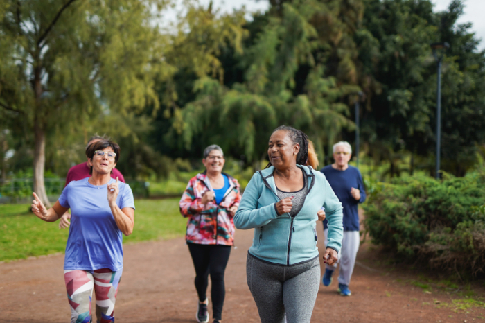 Group of people jogging together outside, smiling